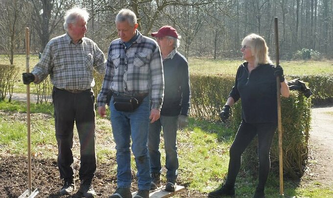 Mit Ski-ähnlichen Holzbrettern wird die frisch gesäte Blumenwiese verfestigt. Foto: NABU Willich